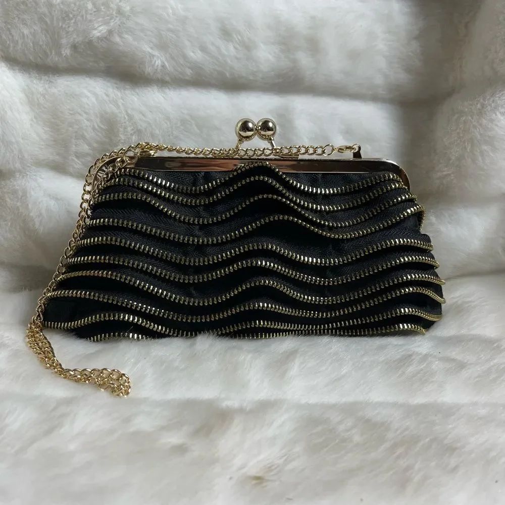 Susan Faris Satin black clutch with gold tone zipper tiered motif and frame.